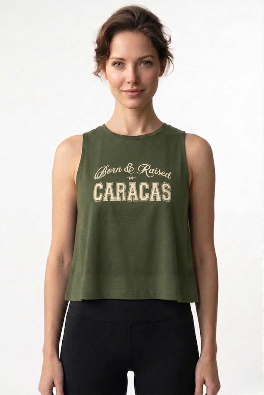 Woman wearing a green sleeveless shirt with 'Born & Raised in Caracas' text on a white background