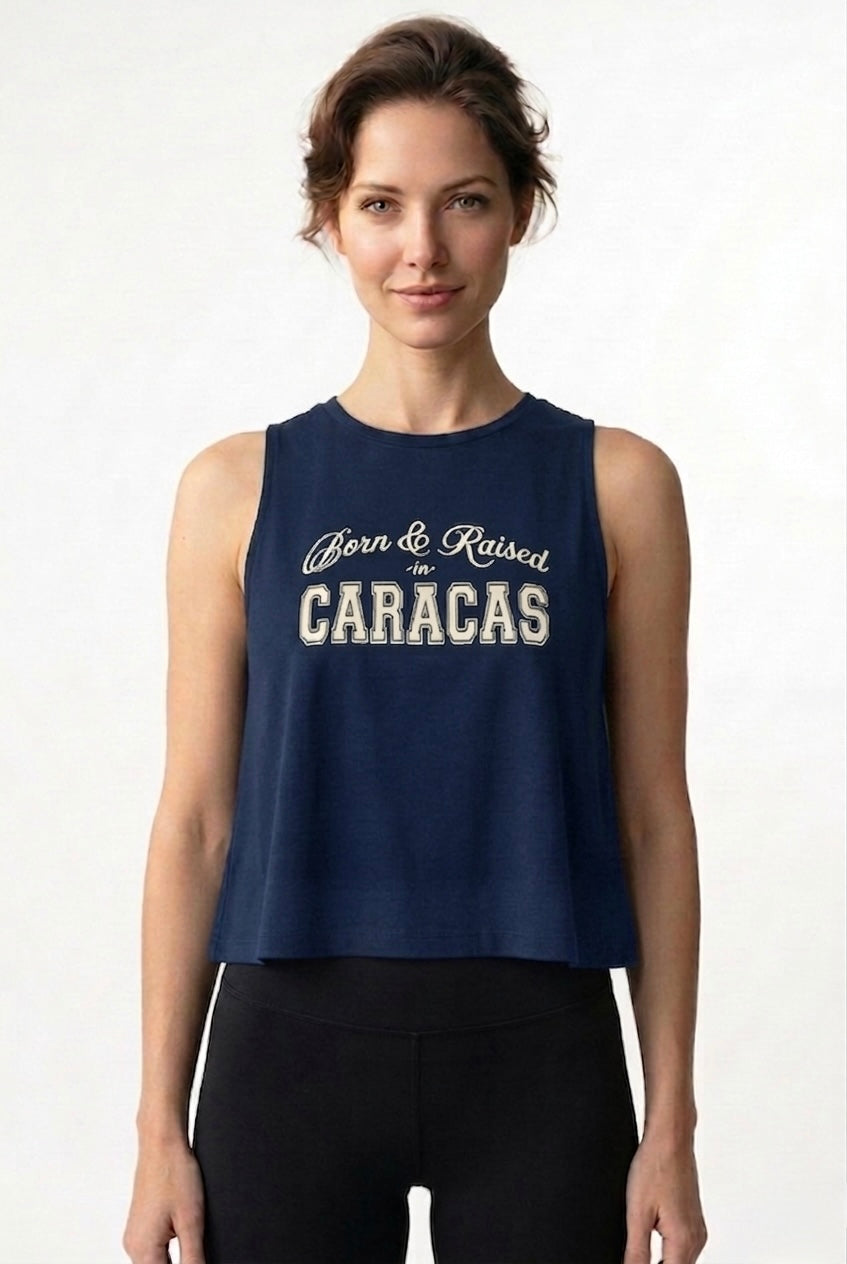 Woman wearing a navy blue sleeveless top with 'Born & Raised in Caracas' text on a white background