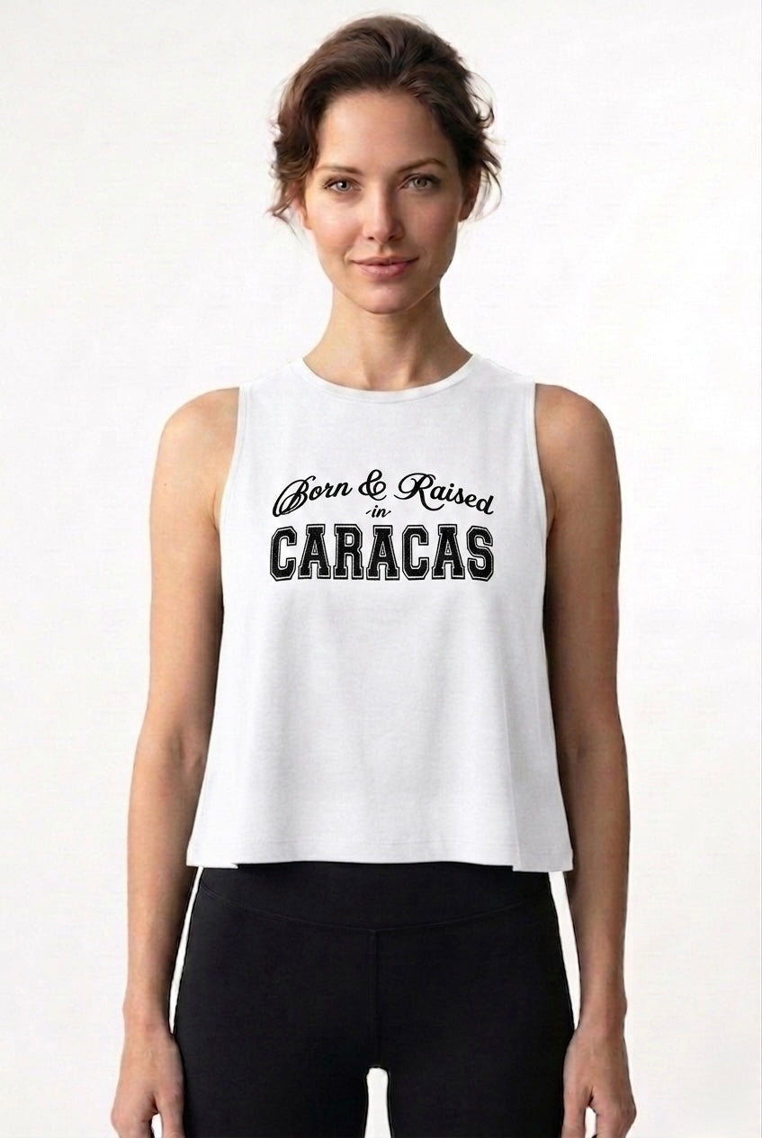 Woman wearing a white sleeveless shirt with 'Born & Raised in Caracas' text on a white background