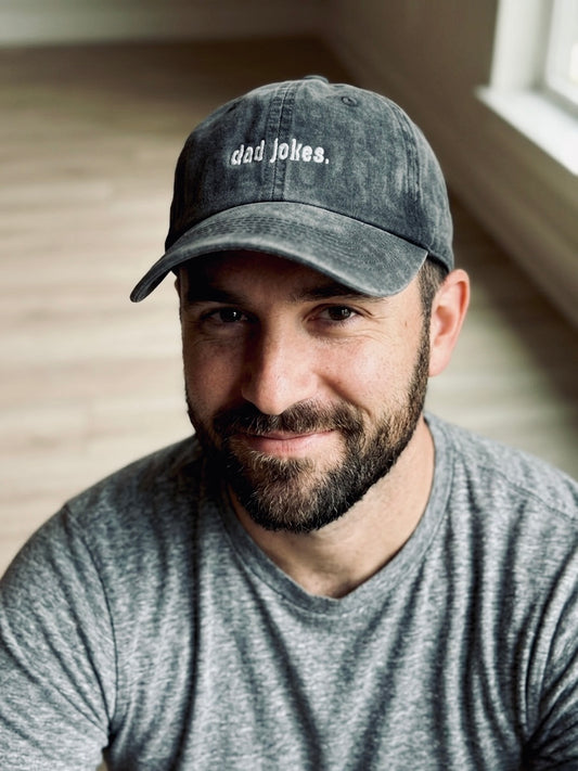 Man wearing a cap with 'dad jokes' text in a casual setting